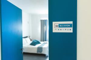 a room with a bed and a door with a sign at B&B a due passi dal mare in Gela