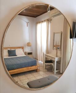 a bedroom with a bed and a table with a mirror at Seamore Pension in Galaxidhion