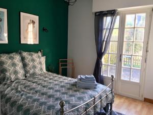 a bedroom with a bed and a green wall at By The Lake in La Trinité-Porhoët