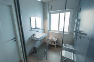 a bathroom with a sink and a mirror and a shower at B&B a due passi dal mare in Gela