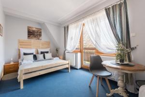 1 dormitorio con cama, escritorio y ventana en Willa Zielony Zakątek, en Zakopane