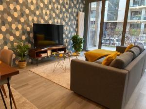 a living room with a couch and a flat screen tv at Bright and chic apartment in Lux City in Luxembourg