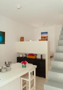 a white kitchen with a white counter and stairs at Rooftop House in the old town of Parikia - Paros in Parikia