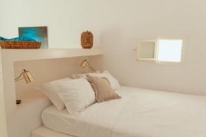 um quarto branco com uma cama e uma janela em Rooftop House in the old town of Parikia - Paros em Parikia