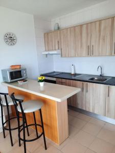 cocina con armarios de madera y encimera blanca en La esquinita, en Los Cristianos