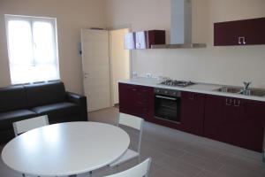 a kitchen with a white table and a white table and a couch at Affittacamere Casamatta in La Morra