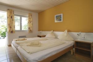 カルヴィにあるFeriendorf zum störrischen Eselのベッドルーム1室(白い大型ベッド1台、テーブル2台付)