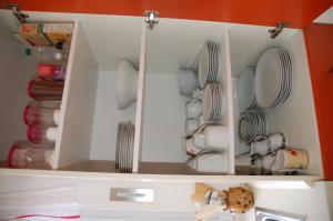 a white cabinet with plates and dishes in it at Ferienwohnung Prey in Ueckermünde