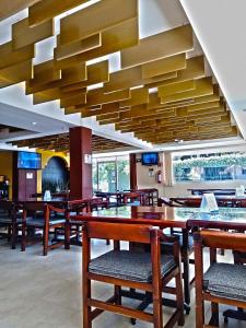 un restaurante con mesas y sillas de madera y un gran techo en Villa Esmeralda, en San Juan Bautista Tuxtepec