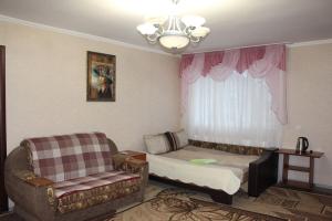 - un salon avec un canapé et une chaise dans l'établissement Kak v gostinice, à Hadyach