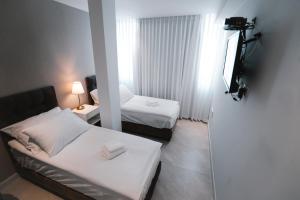 um quarto de hotel com duas camas e uma televisão em Unique Hotel Ashdod em Asdode