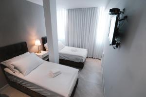 阿什杜德Unique Hotel Ashdod的有两张床和一台电视的酒店房间