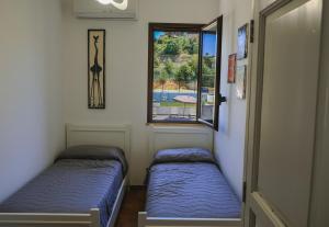 twee bedden in een kamer met een raam bij Giardini Del Golfo in Balestrate +117 foto's