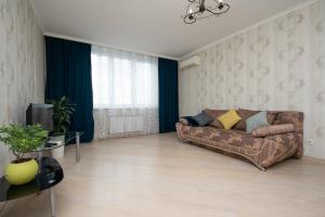 sala de estar con sofá marrón y TV en N.A.N Apartments on Osokorky, en Kiev