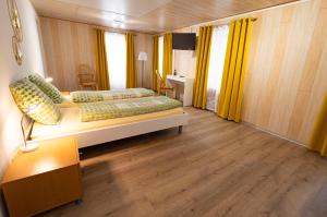 een slaapkamer met 2 bedden en gele gordijnen bij Hôtel Bellavista "Bellevue" in Saignelégier
