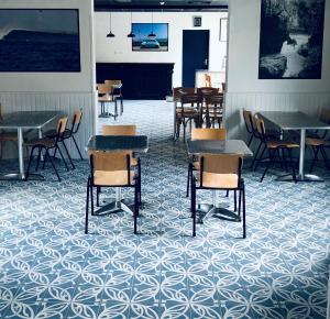 a dining room with tables and chairs and tables and tablesktop at LES BAIGNEURS in Saint-Gilles-Croix-de-Vie