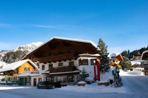 una casa con techo cubierto de nieve en la nieve en Mesnerhaus Filzmoos, en Filzmoos