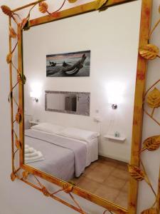 a mirror in a room with a bed and a sink at Affittacamere Guesthouse Maristella in Cagliari +20 photos