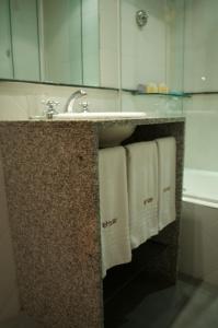 een badkamer met een wastafel en handdoeken op een aanrecht bij Apart San Diego Recoleta in Buenos Aires