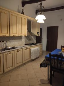 kuchnia z białymi szafkami, zlewem i stołem w obiekcie Anema & Core w mieście Castellammare di Stabia