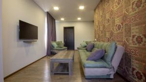a living room with a couch and a tv at Check inn Delisi in Tbilisi City