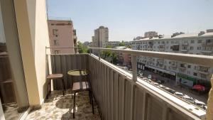 a balcony with a table and chairs and a city at Check inn Delisi in Tbilisi City