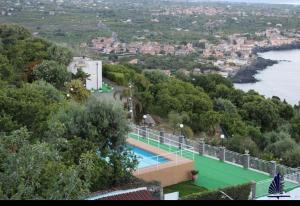 a house with a swimming pool next to a river at Tenuta la Timpa Vela rooms And pool in Acireale