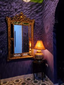 une lampe assise sur une table à côté d'un miroir dans l'établissement Riad Yamina, à Marrakech