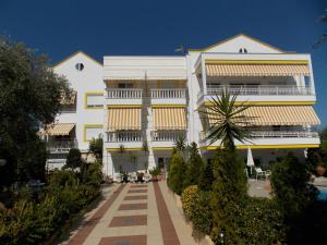 een wit gebouw met gele en witte balkons bij Ioli Apartments in Limenas