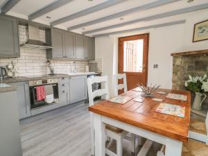 a kitchen with a wooden table and a dining room at Pollard Cottage in Northallerton