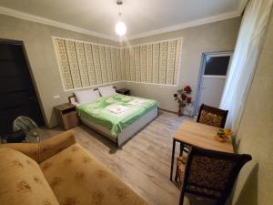 sypialnia z łóżkiem, stołem i kanapą w obiekcie Beehives w Kutaisi