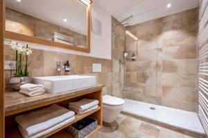 ein Badezimmer mit einem Waschbecken, einem WC und einer Badewanne in der Unterkunft Alperie Ferienhaus in Schliersee