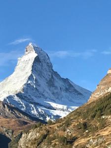 uma montanha coberta de neve no topo de uma colina em Haus Les Mélèzes em Zermatt