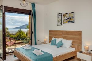 a bedroom with a bed and a balcony at Green Valley Apartments in Herceg-Novi
