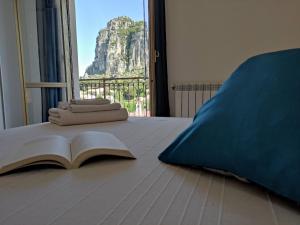 un libro abierto en una cama con vistas a la montaña en Appartamento La Capretta Bianca - Affitti Brevi Italia, en Ulassai