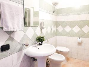 a white bathroom with a sink and a toilet at Appartamento La Capretta Bianca - Affitti Brevi Italia in Ulassai