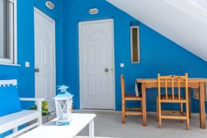 a dining room with blue walls and a table and chairs at Kalithies Studios CDK in Kalithies +8 photos