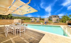 eine Terrasse mit einem Tisch und Stühlen sowie einem Pool in der Unterkunft Allas Villa Heated Pool in Chania