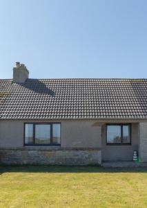 a house with a roof on top of a yard at Greenfield Cottage in Thrumster