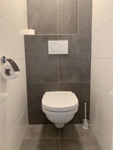 La salle de bains est pourvue de toilettes blanches. dans l'établissement Les Maisons Domburg, à Domburg