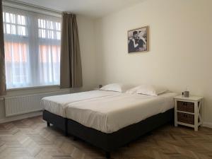 a bedroom with a large bed and a window at Les Maisons Domburg in Domburg