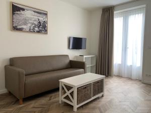 ein Wohnzimmer mit einem Sofa und einem Tisch in der Unterkunft Les Maisons Domburg in Domburg