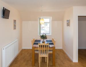 a dining room with a table with chairs and a window at Seaview Apartment in Keiss