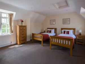 a bedroom with two beds and a dresser at Lord High Admiral in Winchcombe