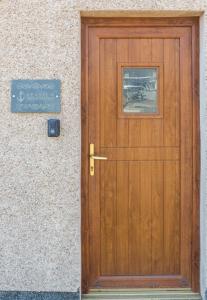 a wooden door to a building with a sign on it at Seaview Apartment in Keiss