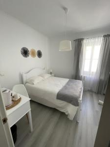 Habitación blanca con cama blanca y escritorio. en Casa de Hospedes D. Maria Parreirinha, en Sintra