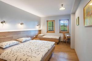 a bedroom with two beds and a chair in it at Apartments Tourist farm Matijovc in Naklo