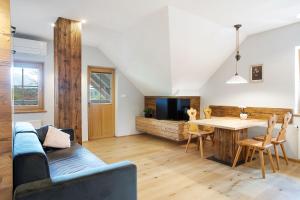 ein Wohnzimmer mit einem Sofa und einem Esstisch in der Unterkunft Apartments Tourist farm Matijovc in Naklo