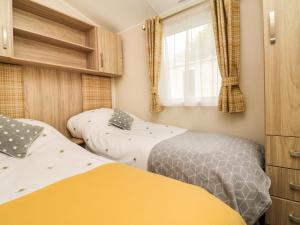 a bedroom with two beds and a window at Ochenta in Combe Martin
