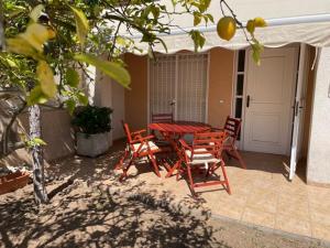 un patio con mesa, sillas y sombrilla en CASA LIMÓN, en Cunit